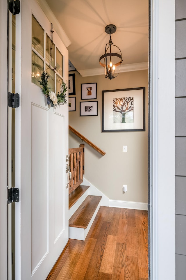 interior space featuring crown molding, a chandelier, and hardwood / wood-style flooring