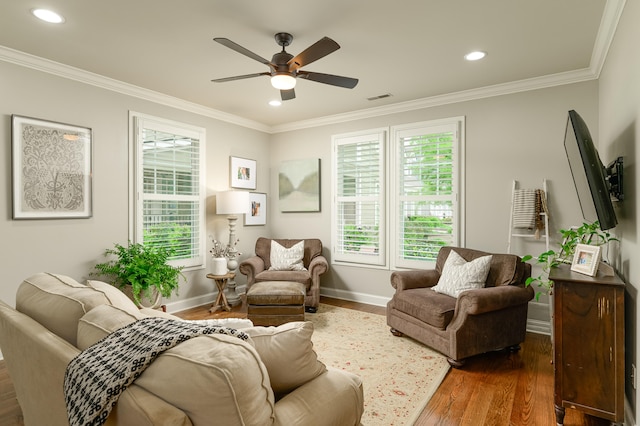 living room featuring dark hardwood / wood-style flooring, ceiling fan, and ornamental molding