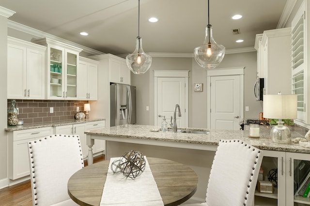 kitchen featuring light stone countertops, stainless steel appliances, dark hardwood / wood-style floors, pendant lighting, and white cabinets