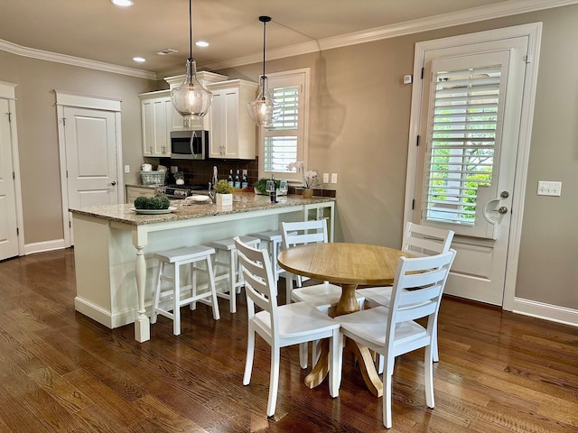 dining space featuring crown molding, recessed lighting, and dark wood-style flooring