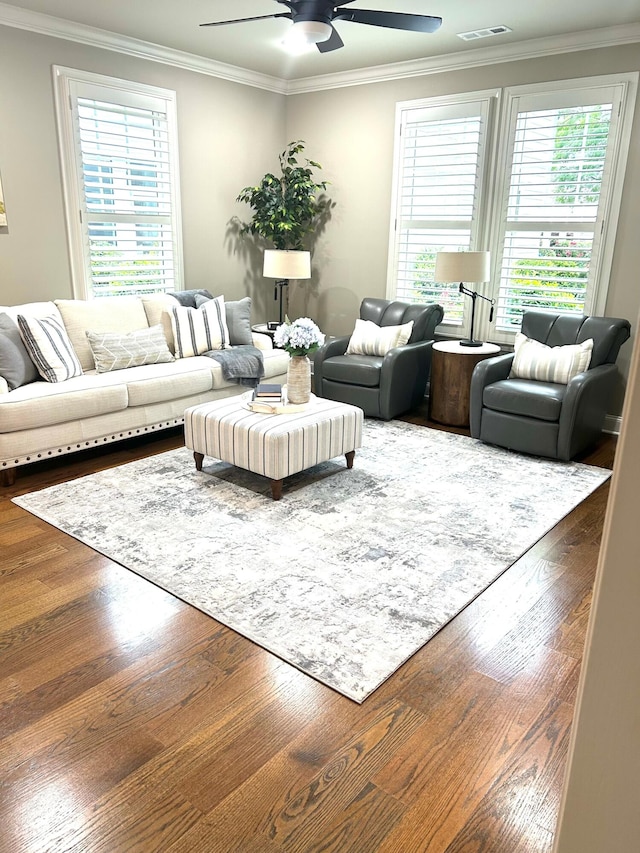living area featuring visible vents, crown molding, ceiling fan, and wood finished floors