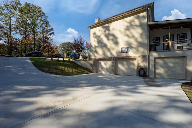 view of side of home featuring a balcony and a garage