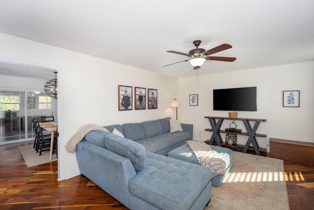 living room with ceiling fan and dark wood-type flooring