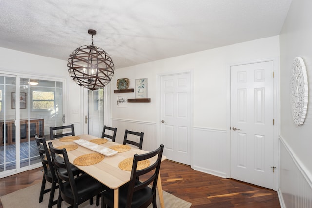 dining room featuring a textured ceiling, dark hardwood / wood-style floors, and an inviting chandelier