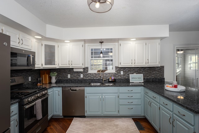 kitchen with white cabinetry, sink, dark wood-type flooring, tasteful backsplash, and appliances with stainless steel finishes