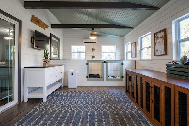 interior space with wooden walls, vaulted ceiling with beams, dark wood-type flooring, and plenty of natural light