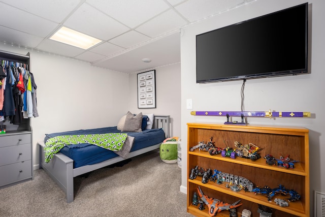 bedroom featuring carpet flooring and a drop ceiling