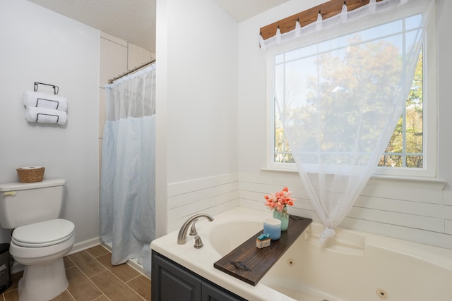 bathroom featuring toilet, a tub to relax in, and a textured ceiling