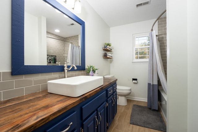 bathroom featuring backsplash, hardwood / wood-style floors, vanity, and toilet