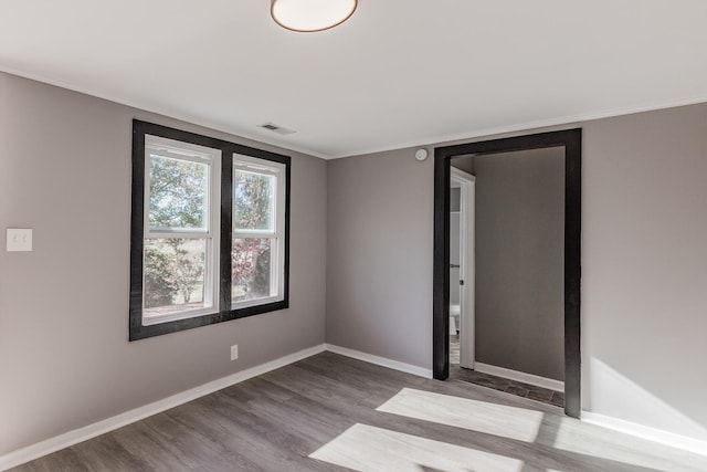 unfurnished room with light wood-type flooring and crown molding