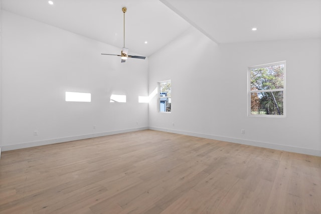 empty room featuring light hardwood / wood-style floors, ceiling fan, and high vaulted ceiling