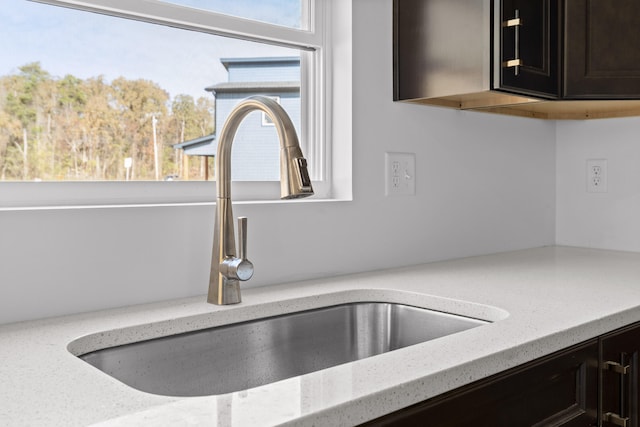 interior details featuring light stone countertops and sink