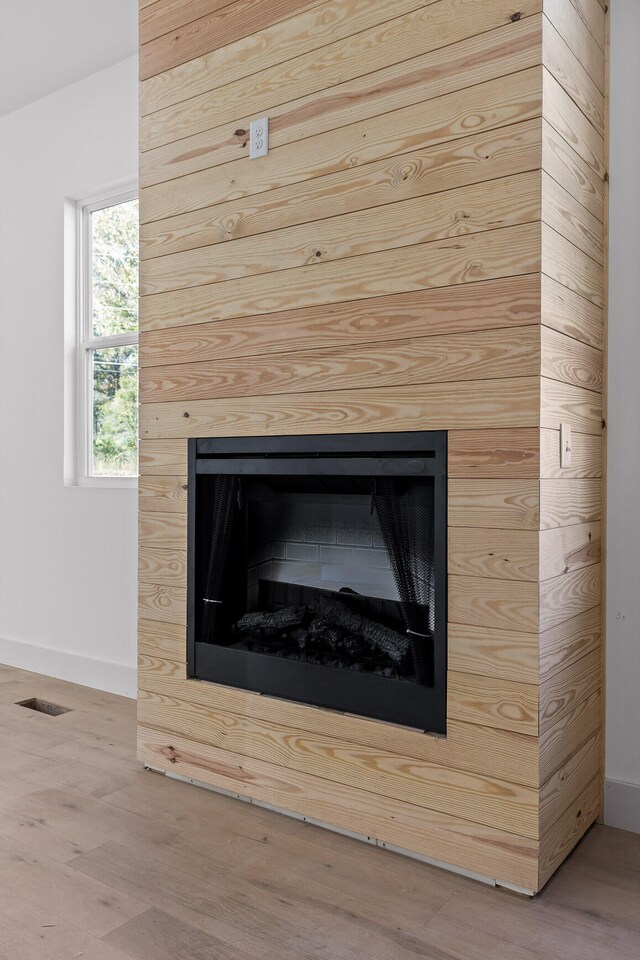 details featuring hardwood / wood-style floors, a fireplace, and wooden walls