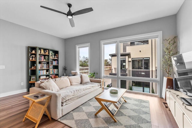 living room with ceiling fan and light hardwood / wood-style flooring