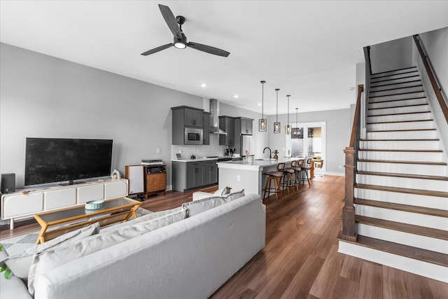 living room with ceiling fan, dark wood-type flooring, and sink