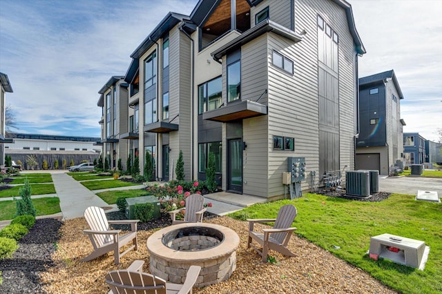 back of house featuring a yard, cooling unit, and an outdoor fire pit