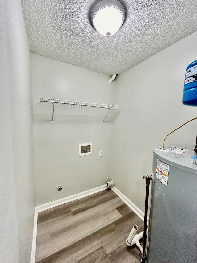 laundry room featuring a textured ceiling, electric dryer hookup, wood-type flooring, electric water heater, and hookup for a washing machine