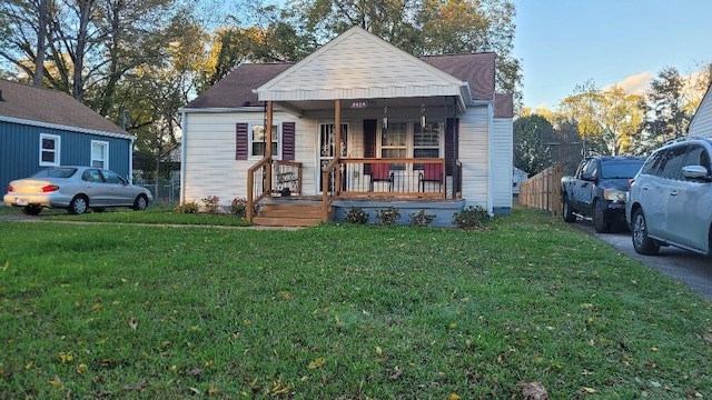 bungalow-style home featuring covered porch and a front lawn