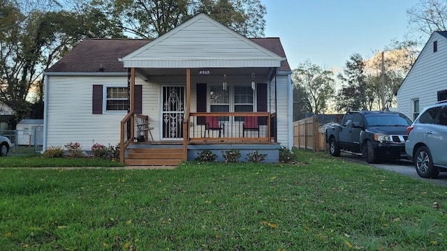 bungalow-style home featuring covered porch and a front lawn