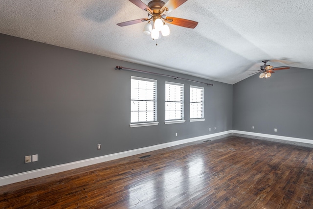 spare room with lofted ceiling, ceiling fan, dark hardwood / wood-style floors, and a textured ceiling