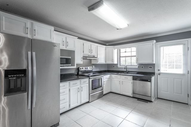 kitchen with white cabinetry, crown molding, light tile patterned floors, and appliances with stainless steel finishes