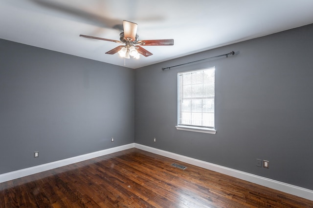 empty room with dark hardwood / wood-style flooring and ceiling fan