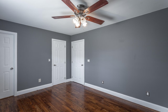 unfurnished bedroom with ceiling fan and dark hardwood / wood-style flooring