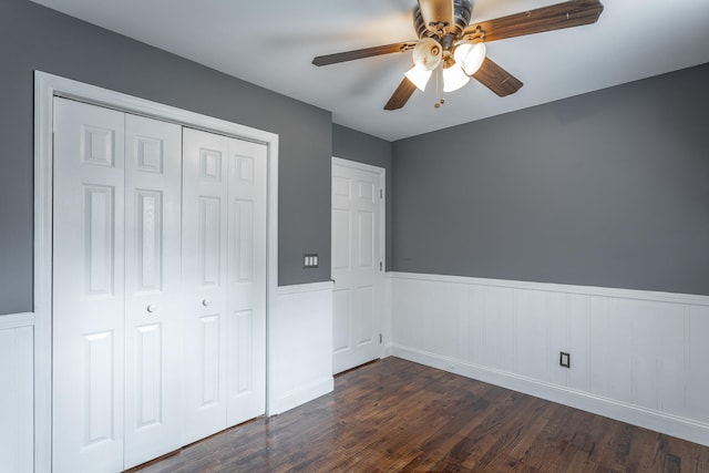 unfurnished bedroom featuring ceiling fan, a closet, and dark wood-type flooring