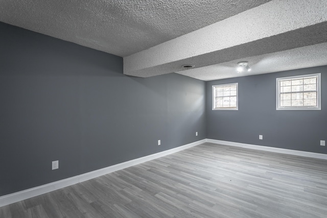 basement with hardwood / wood-style floors and a textured ceiling