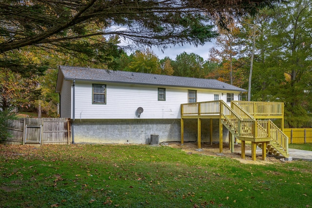 rear view of house with central air condition unit, a lawn, and a deck