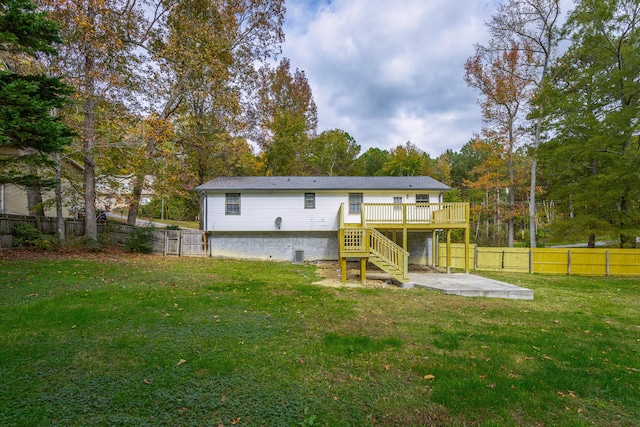 rear view of property with a lawn, a wooden deck, and a patio area