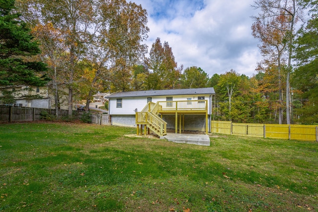 rear view of property featuring a yard and a deck