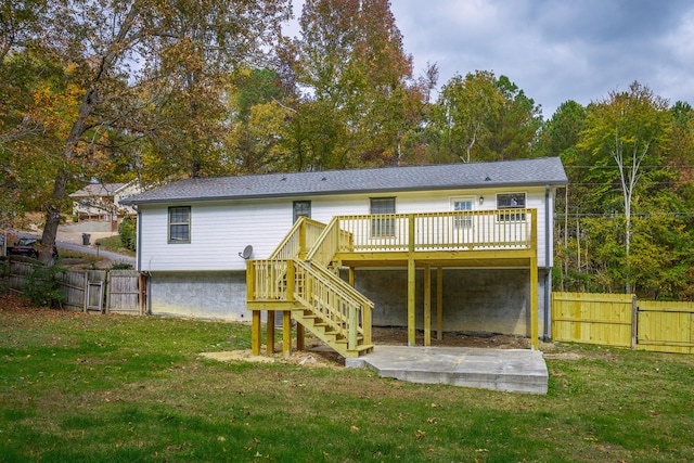 rear view of property with a wooden deck and a yard