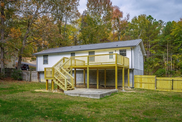 back of property featuring a lawn, a wooden deck, and a patio area