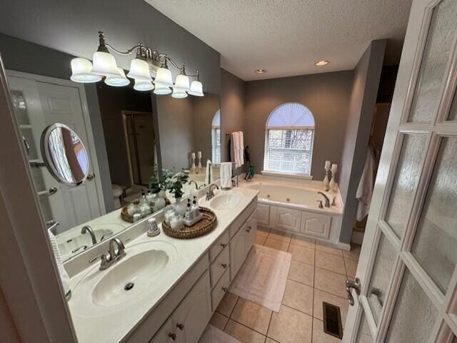 bathroom featuring vanity, a tub, tile patterned floors, and a textured ceiling