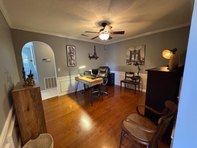 office featuring crown molding, ceiling fan, a textured ceiling, and hardwood / wood-style flooring