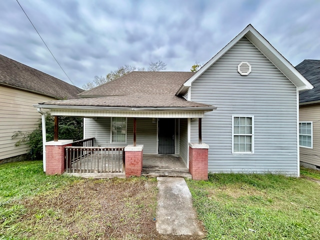 bungalow-style home with a front yard and covered porch