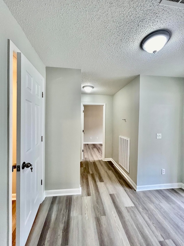 interior space featuring a textured ceiling and hardwood / wood-style flooring