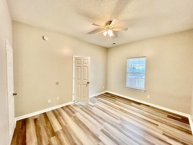 spare room featuring ceiling fan, a textured ceiling, and light hardwood / wood-style floors