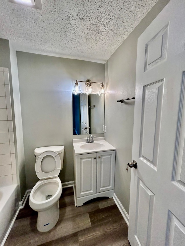 bathroom featuring hardwood / wood-style flooring, vanity, toilet, and a textured ceiling