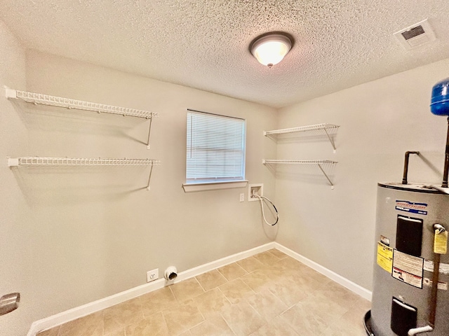 washroom with water heater, hookup for a washing machine, and a textured ceiling