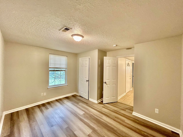 unfurnished bedroom featuring light hardwood / wood-style floors and a textured ceiling