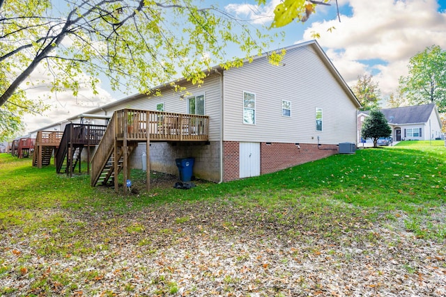 back of house with a wooden deck, a lawn, and central AC