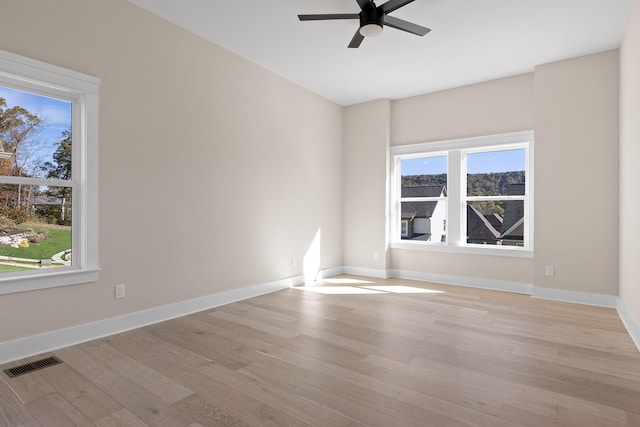 spare room with plenty of natural light, ceiling fan, and light hardwood / wood-style flooring