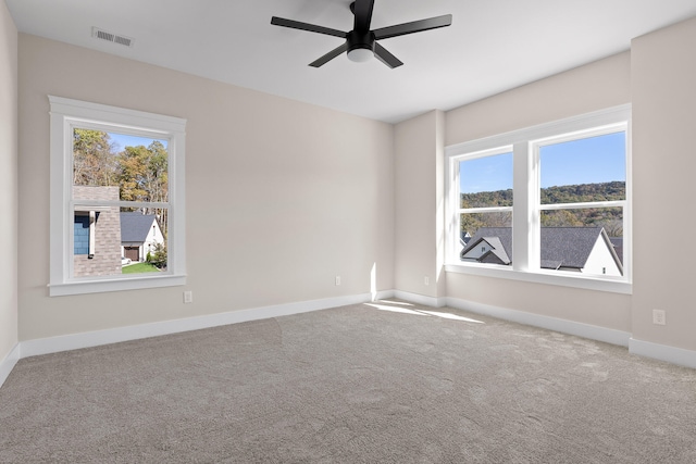 carpeted empty room with plenty of natural light and ceiling fan