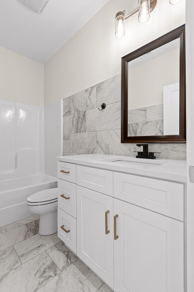 full bathroom featuring shower / bathing tub combination, vanity, tile walls, and toilet