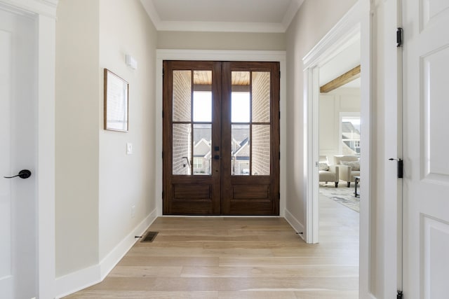 foyer entrance with french doors, light hardwood / wood-style flooring, and ornamental molding