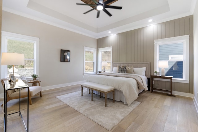 bedroom featuring a raised ceiling, ceiling fan, and light hardwood / wood-style floors