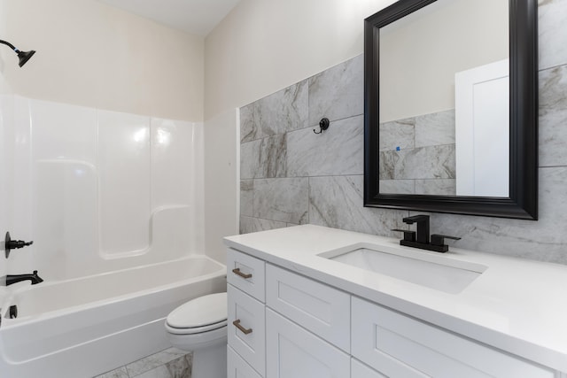 full bathroom with toilet, vanity, tile walls, and washtub / shower combination