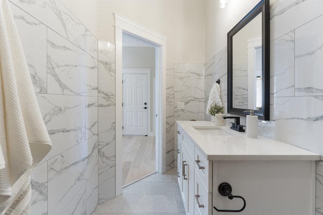 bathroom with vanity and tile walls